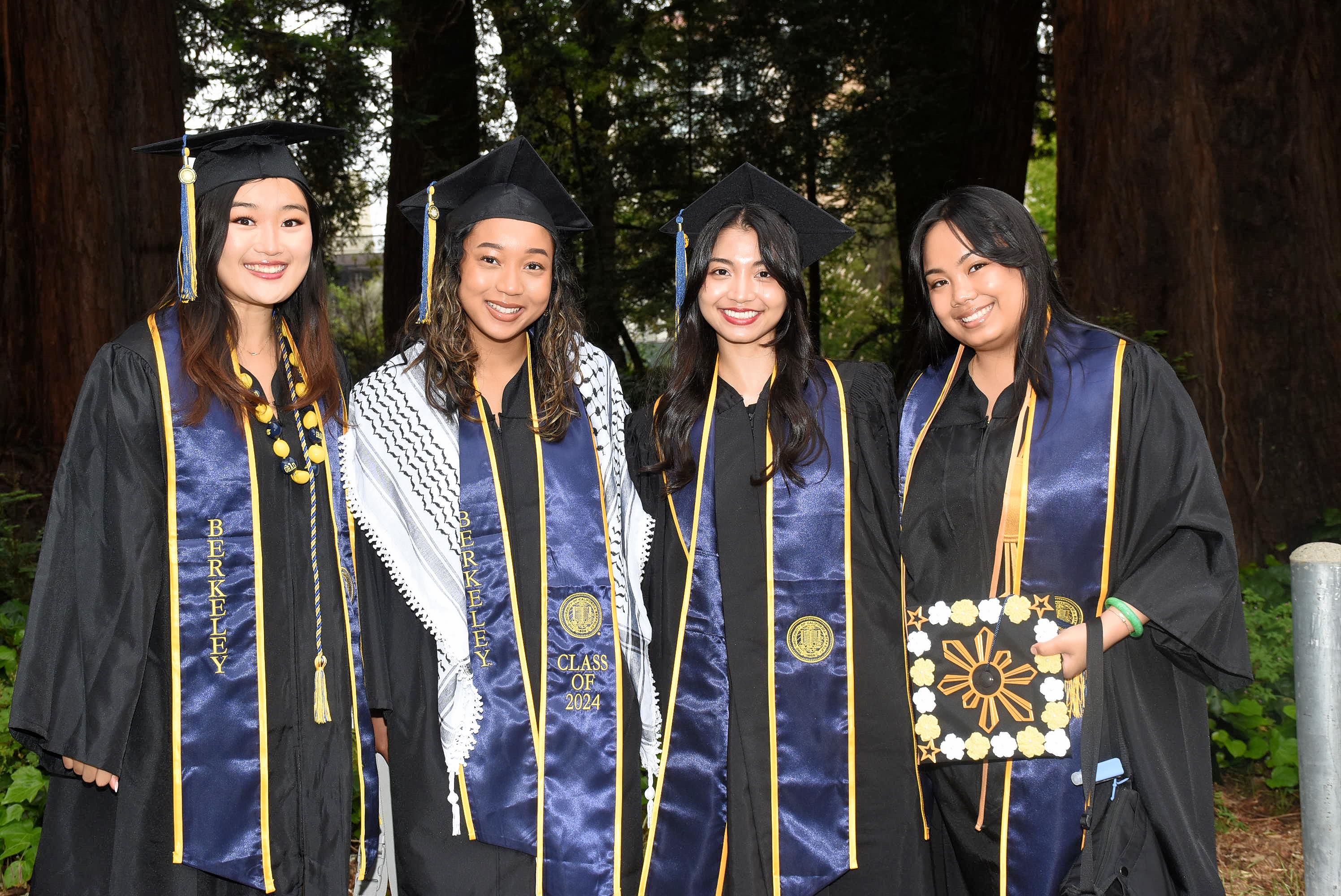 Four grads smile at camera