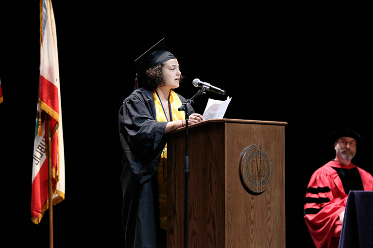 Graduate speaks at podium