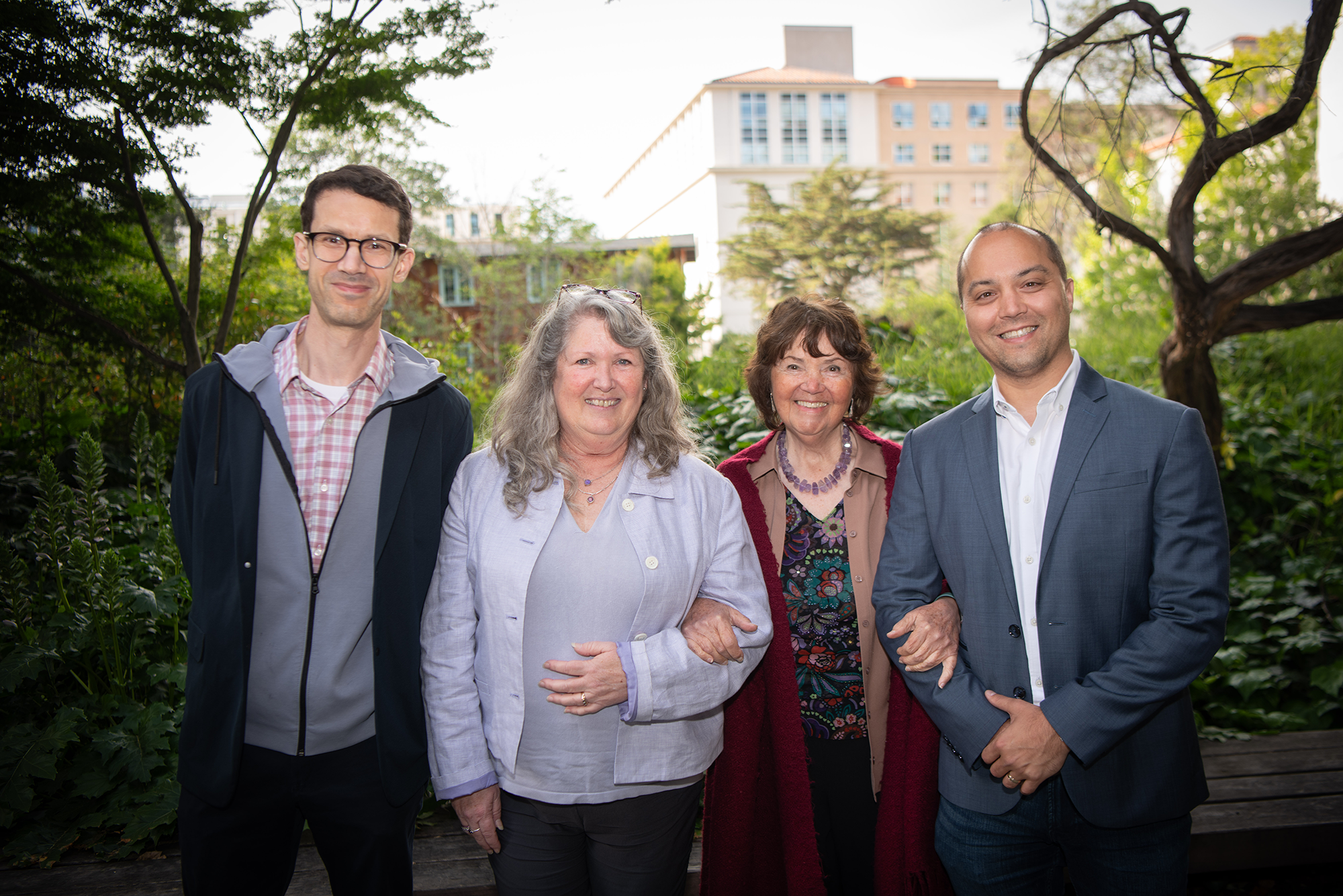 Four people stand together in a row