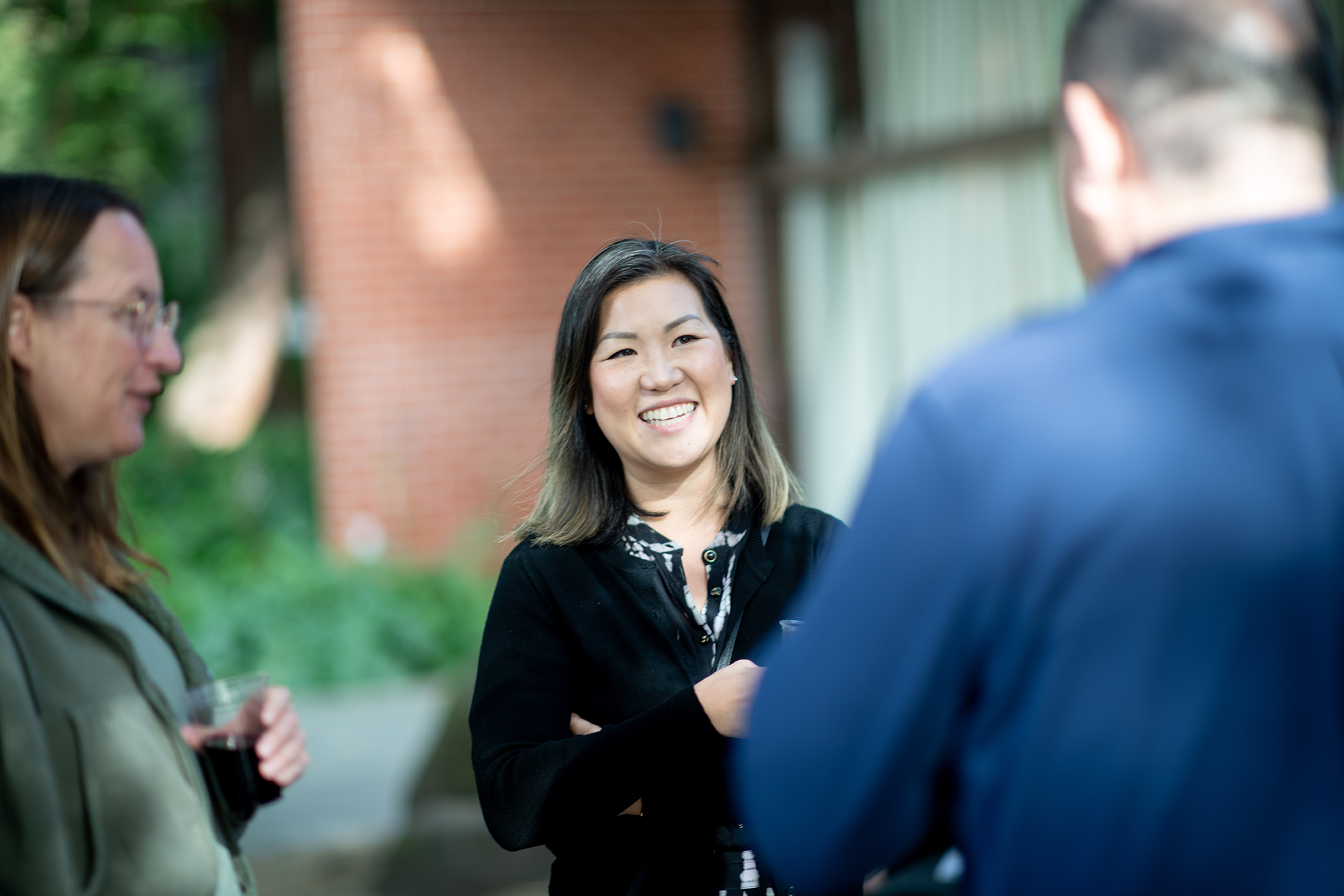 Person in conversation with others smiles while chatting