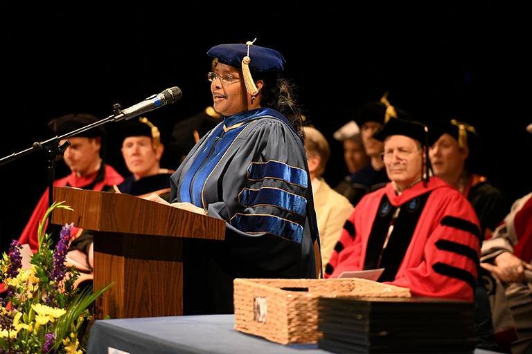 Woman speaks at podium during commencement