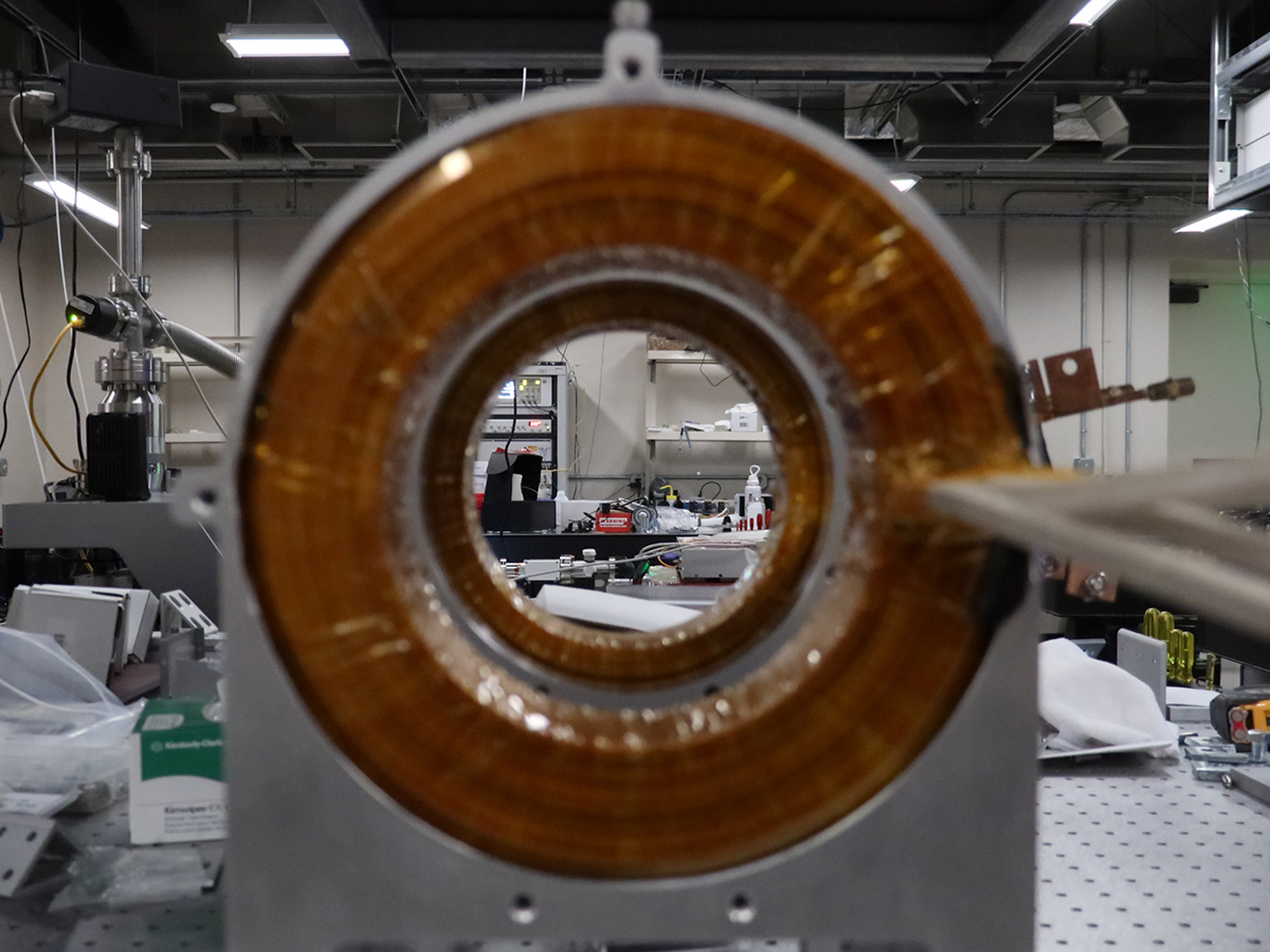 A messy part of the lab is viewed through the center of bronze-colored metal coils 