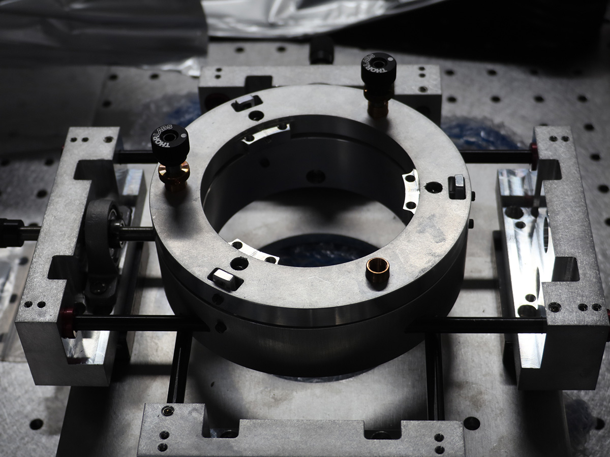 A circular object rests in the middle of rectangular brackets
