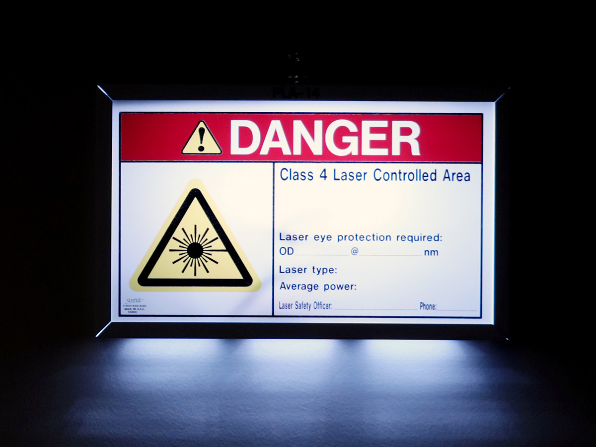 An illuminated warning sign states, "DANGER: Class 4 Laser Controlled Area"