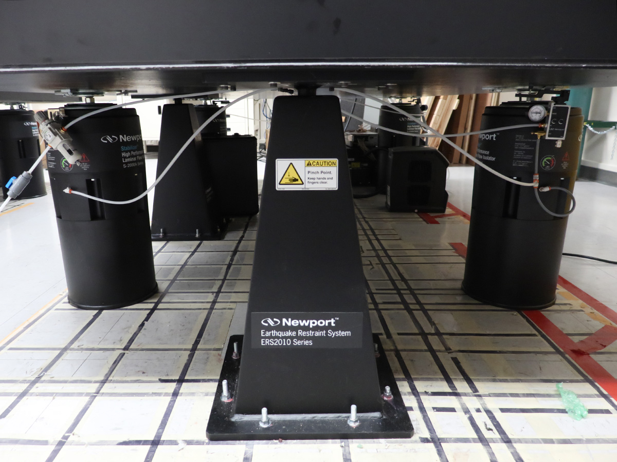 A table slab rests on several black cylinders and pyramids. One says "Newport(TM) Earthquake Restraint System ERS2010 Series."