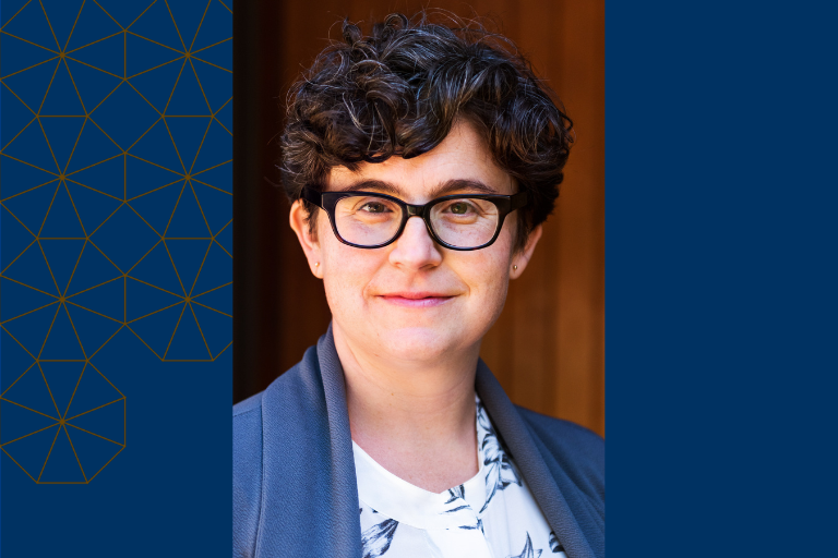 Headshot of Caitlin Rosenthal; person with dark short hair wearing glasses and a blue jacket