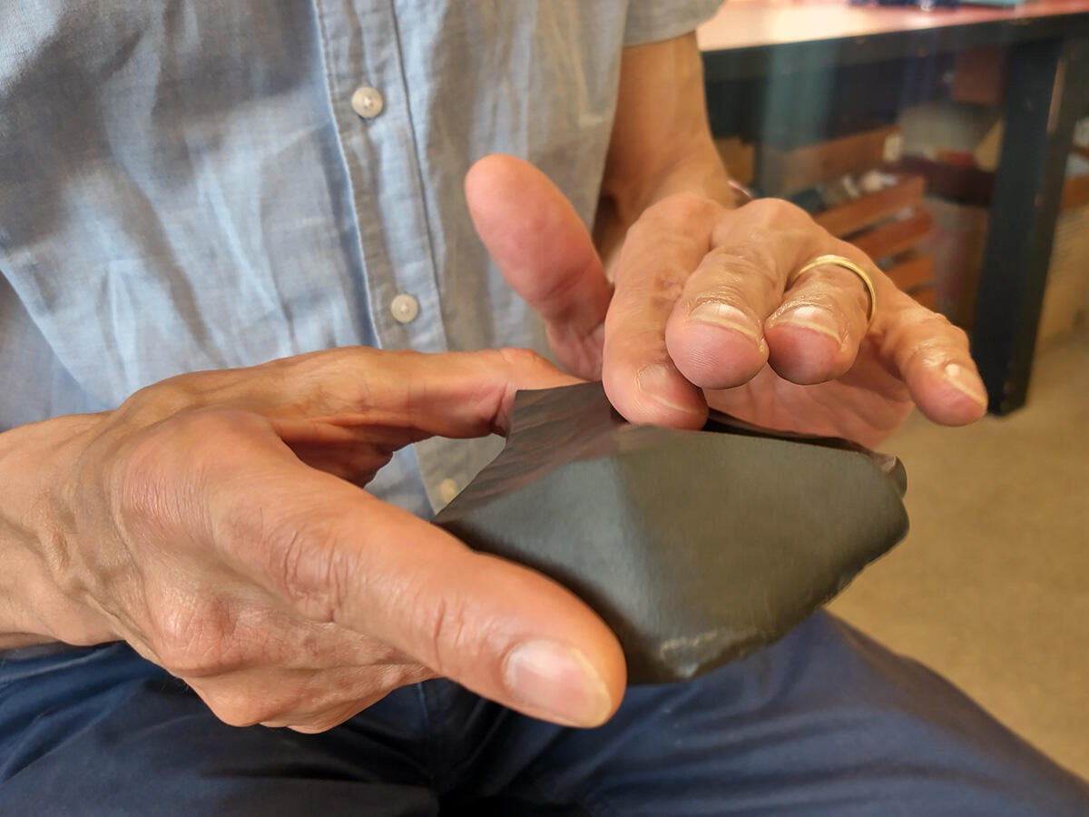 Michael Manga holds a dark, smooth rock in his two hands