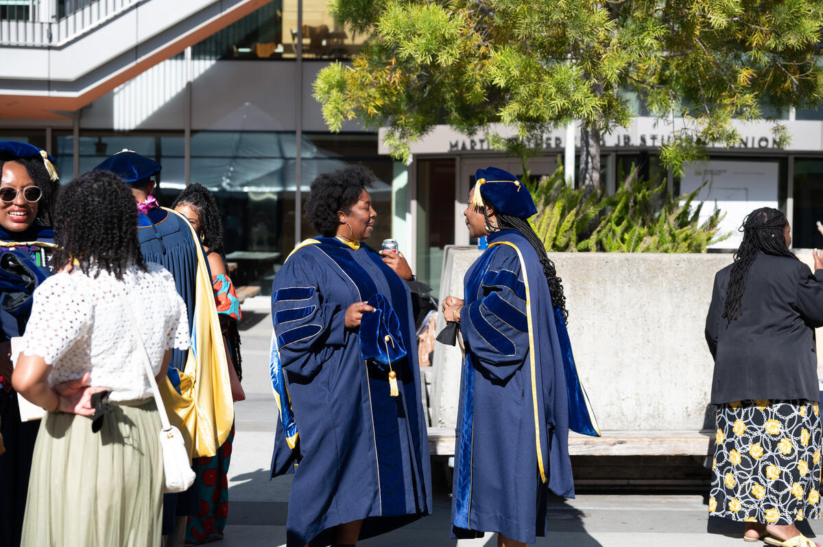 Two graduates having a conversation outside MLK center after the ceremony