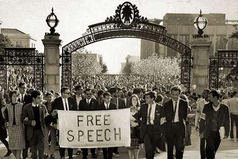 Free Speech Movement archival photo featuring students marching under Sather Gate on UC Berkeley campus.