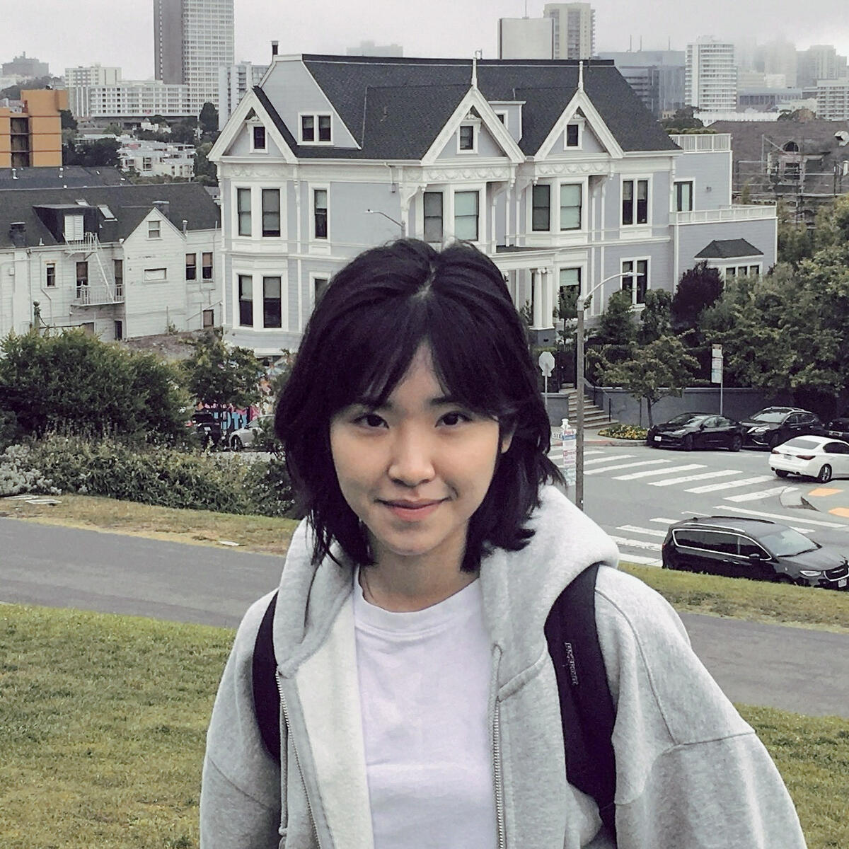 Woman with short dark hair wearing a gray hoodie