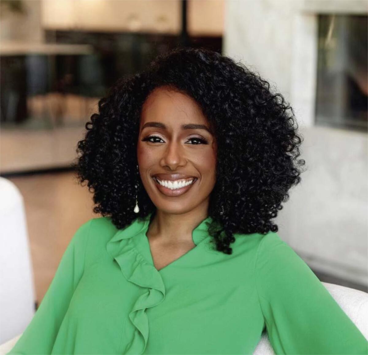 Photo of Jasmin Brooks Stephens in a green shirt, smiling at camera