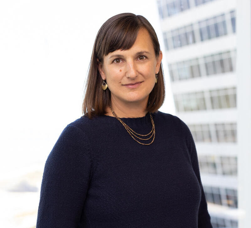 Photo of a woman with dark brown hair and a dark blue sweater