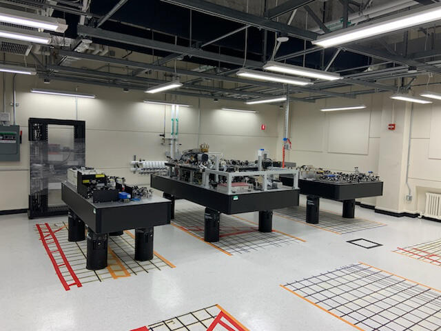 Three tables loaded with equipment in a mostly bare room