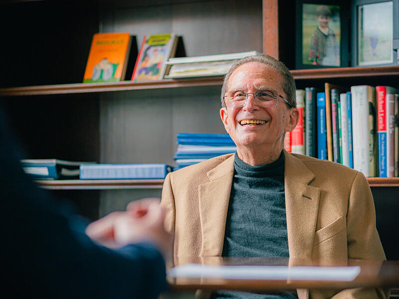 Michael Botchan smiles while seated in his Durant Hall office