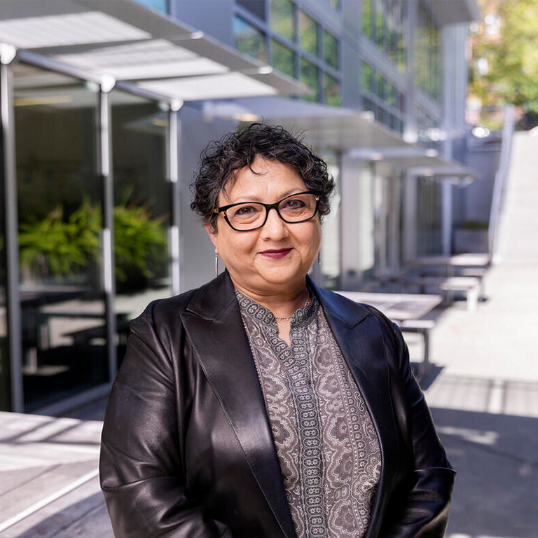 Headshot of Raka Ray standing in front of a building outdoors