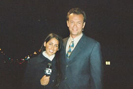 A woman holding a microphone and a man in a suit