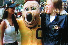 A woman in a Cal hat, Cal's Oski Bear mascot, and a woman in a Cal jacket