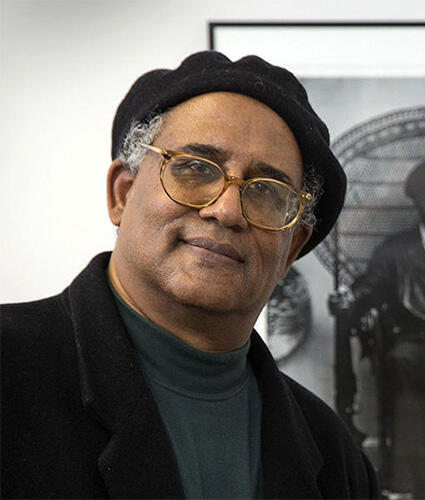 A man stands in front of a famous photo of Huey P. Newton