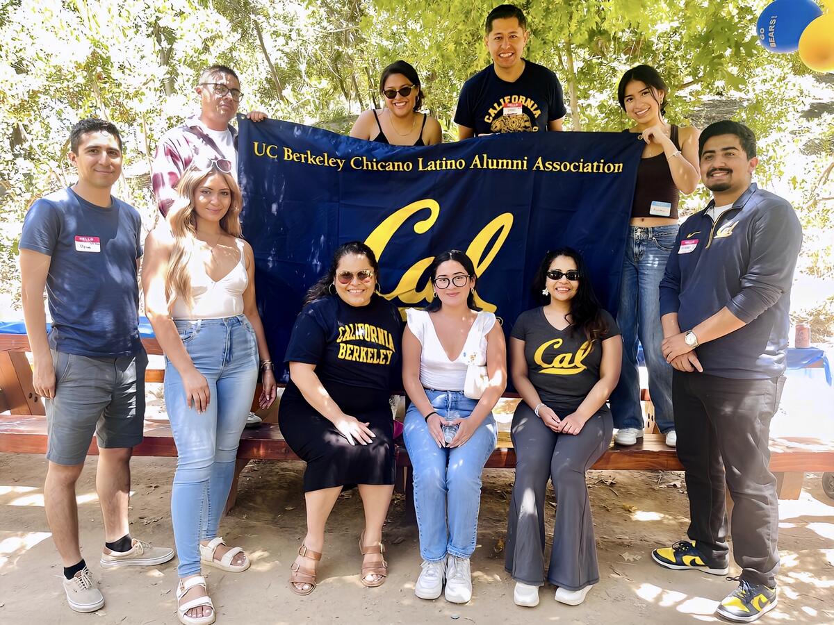 Group of people holding a banner: UC Berkeley Chicano Latino Alumni Association - Cal