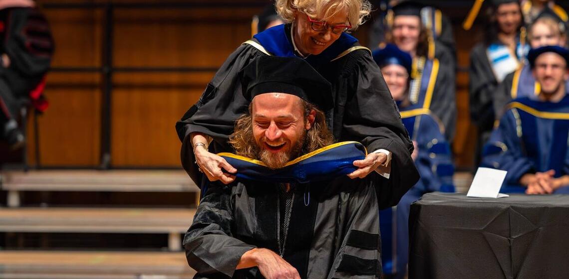 Doctoral graduate is hooded at commencement