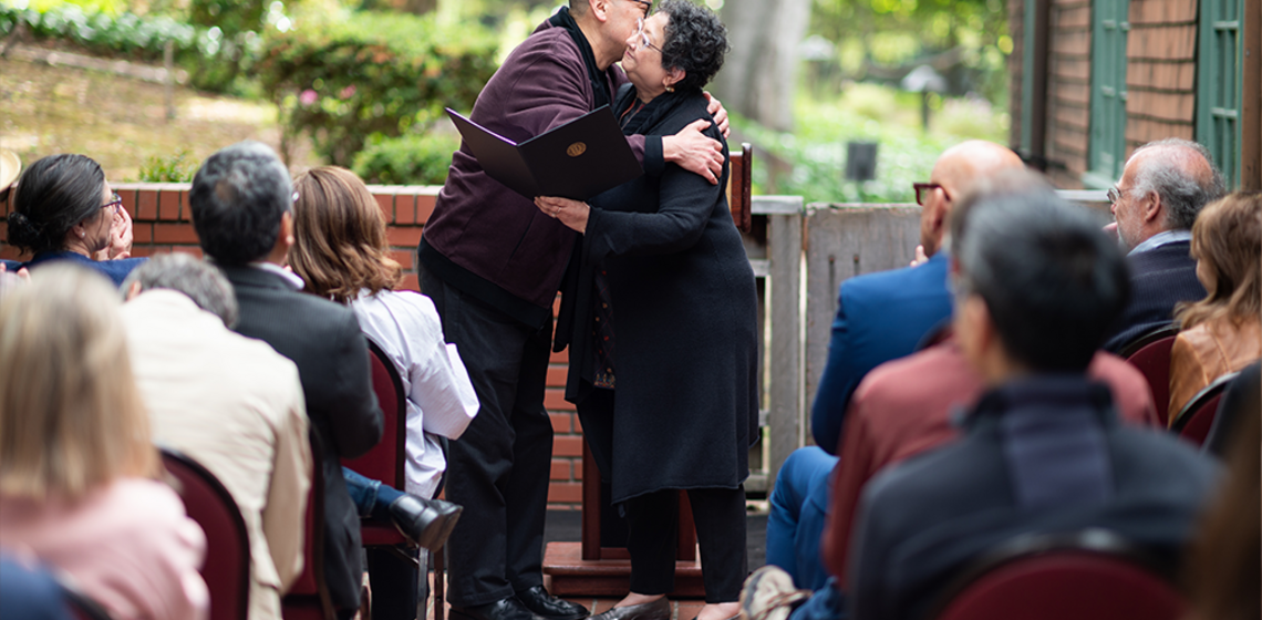 Man and woman embrace during award presentation
