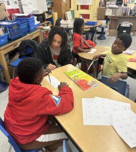 Bryce Wallace tutoring students at a desk