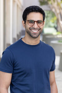 Headshot of Ahmad Nabhan wearing a blue t-shirt and glasses