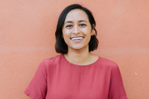 Headshot of Carolina Talavera against a pink backdrop