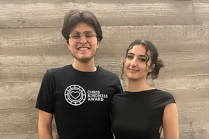 Two students posing for photo; one wearing t-shirt that says Chris Kindess Award