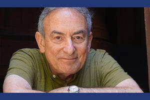 Portrait of Ken Ribet wearing a green shirt with a dark background