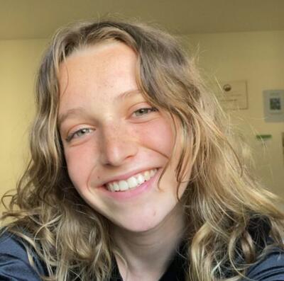 Headshot of Cathy Kenderski, young woman with blond wavy hair, smiling at camera