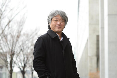 Man wearing glasses standing outside in a dark coat