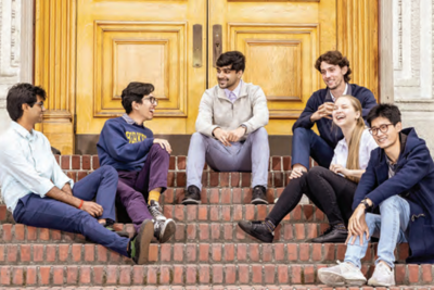 A group of six students from the Quantum Computing Club sit on steps in front of a building